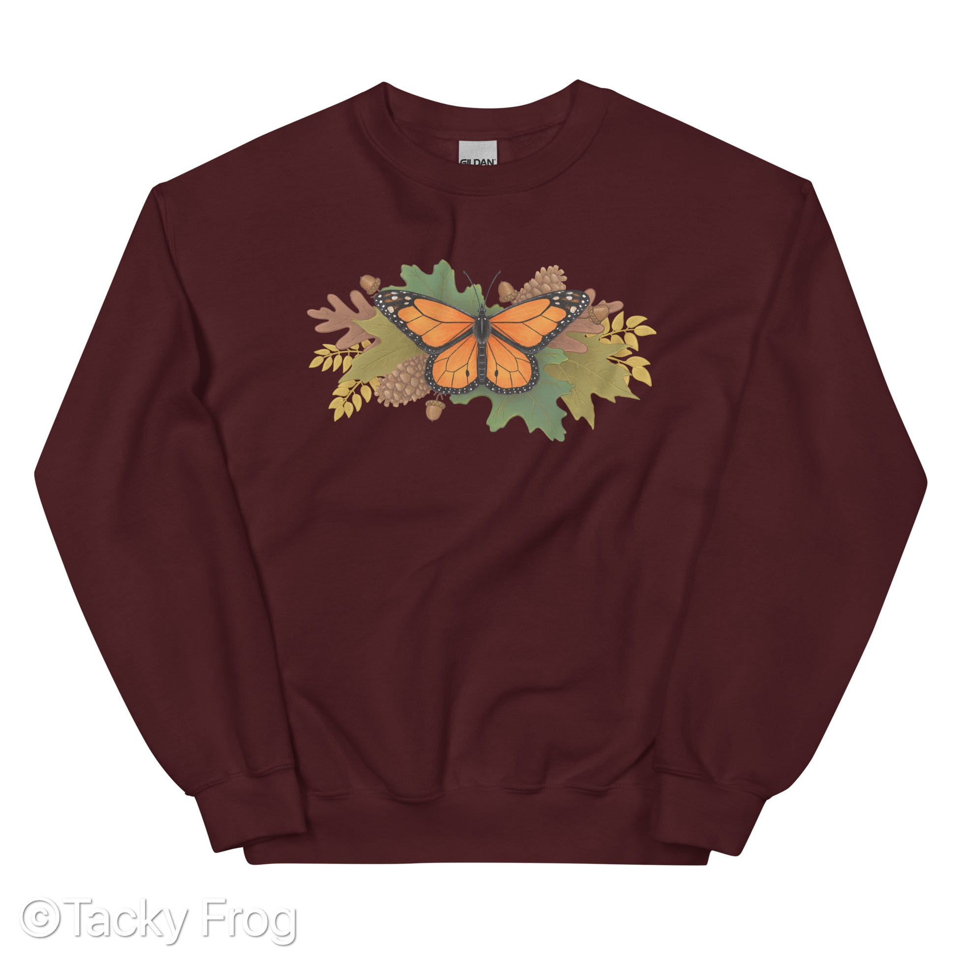 A mockup of a maroon sweatshirt with a monarch butterfly and autumn leaves on it.