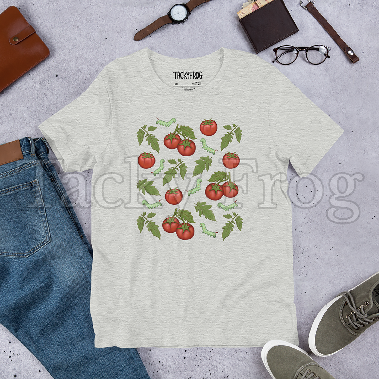 A mockup of an athletic heather-colored tomato hornworm caterpillar t-shirt amongst some clutter.