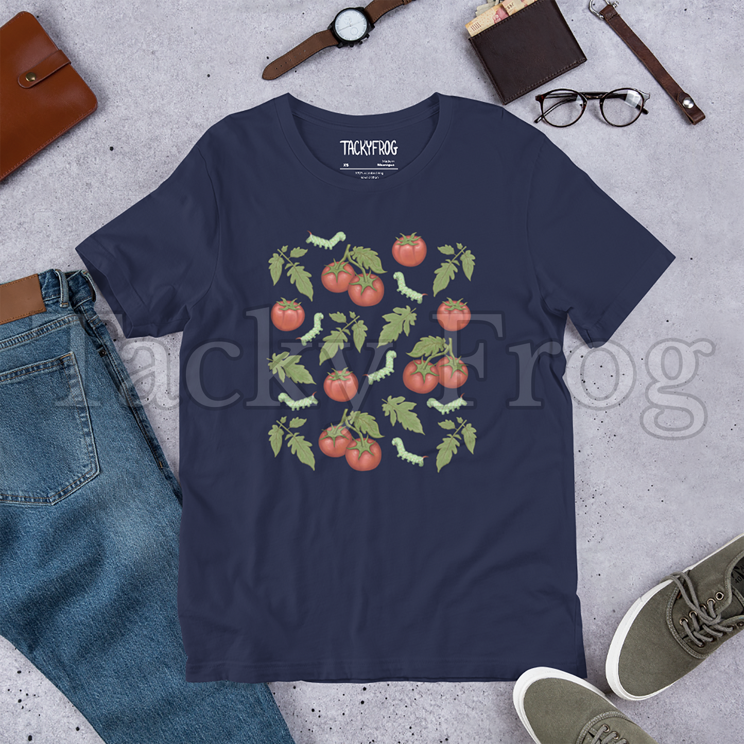 A mockup of a navy-colored tomato hornworm caterpillar t-shirt amongst some clutter.