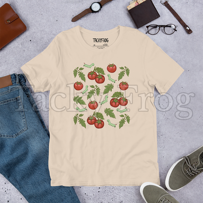 A mockup of a soft cream-colored tomato hornworm caterpillar t-shirt amongst some clutter.