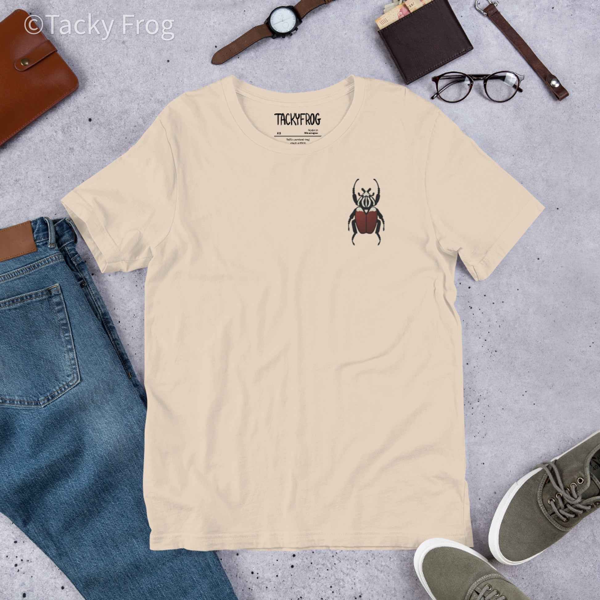 A mockup of the Goliath beetle embroidered t-shirt in the color Soft Cream.