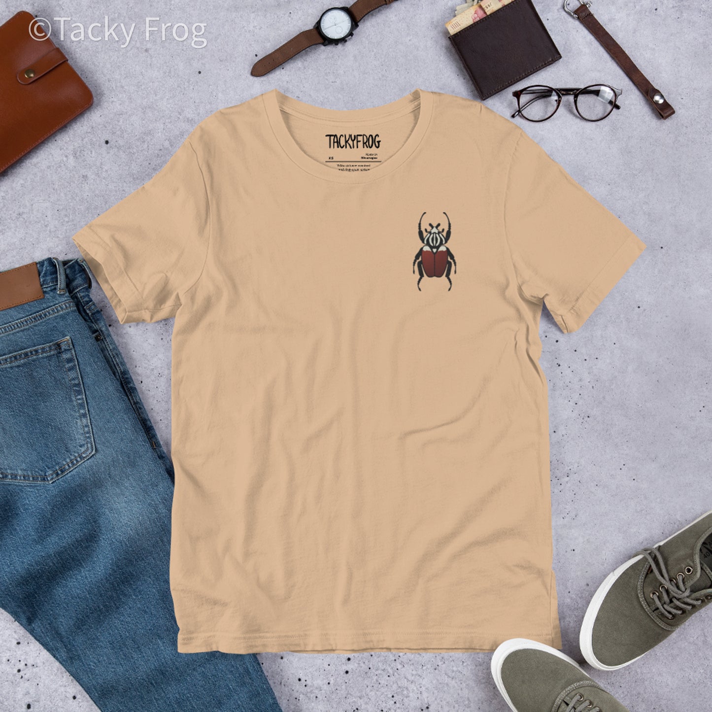 A mockup of the Goliath beetle embroidered t-shirt in the color Tan.